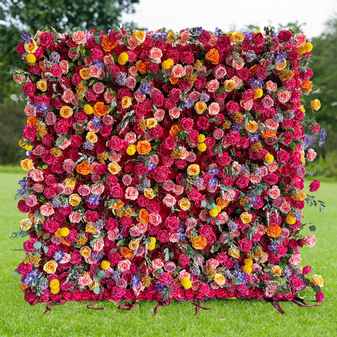 This artificial flower wall is a vibrant and eye - catching decoration. It is densely covered with a rich variety of colorful flowers, including roses in shades of pink, red, and orange, along with yellow and purple blooms. The flowers are interspersed with green leaves, creating a lush and opulent appearance. Ideal for events, it offers a striking backdrop.