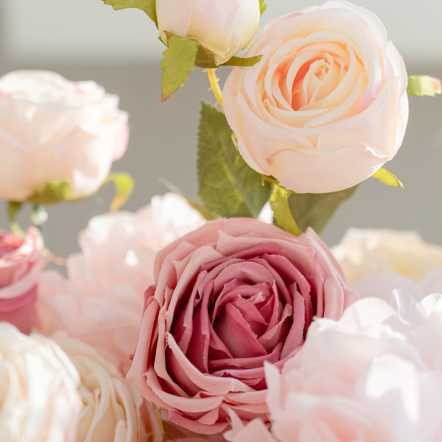 A close - up of a collection of soft - colored roses. The blooms include shades of pale pink, light peach, and creamy white, creating a delicate and romantic floral arrangement.