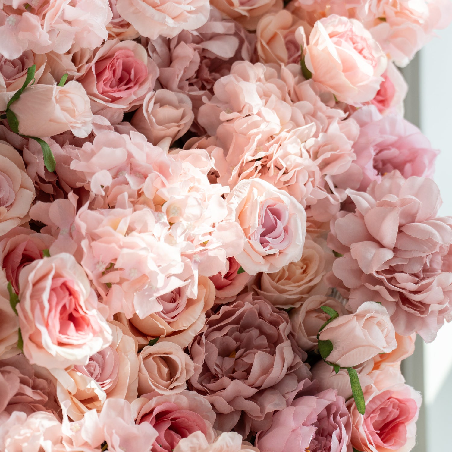 This image showcases a close - up of a floral carpet. The wall is densely packed with large, soft - pink roses, creating a romantic and elegant appearance. The petals are intricately layered, and the overall color scheme is a delicate blend of pastel pinks. This type of floral wall is often used for decorative purposes in events like weddings, parties, or photo shoots.