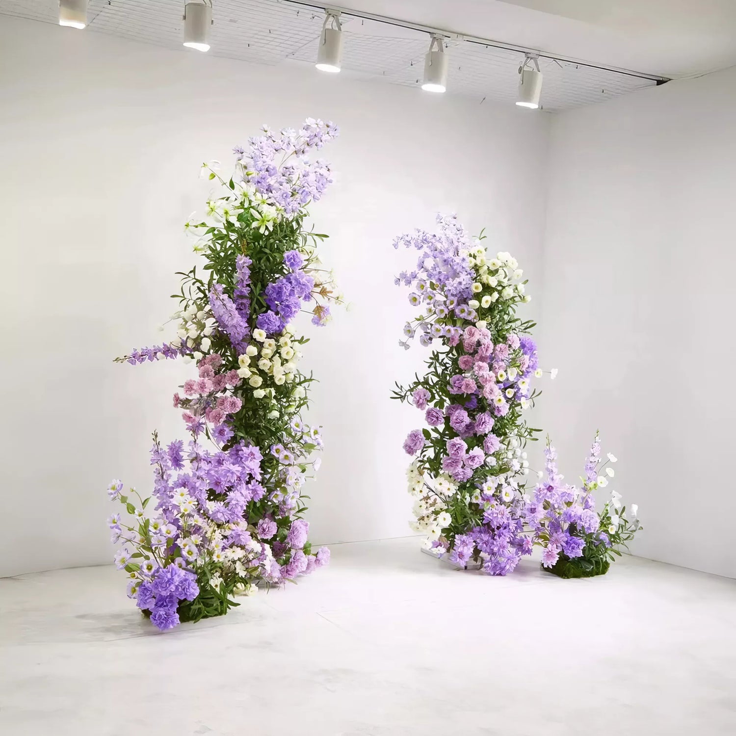 Minimalist floral arches with lush greenery and purple flowers. The simple, elegant design creates a serene and modern aesthetic, ideal for weddings, photoshoots, or intimate gatherings.