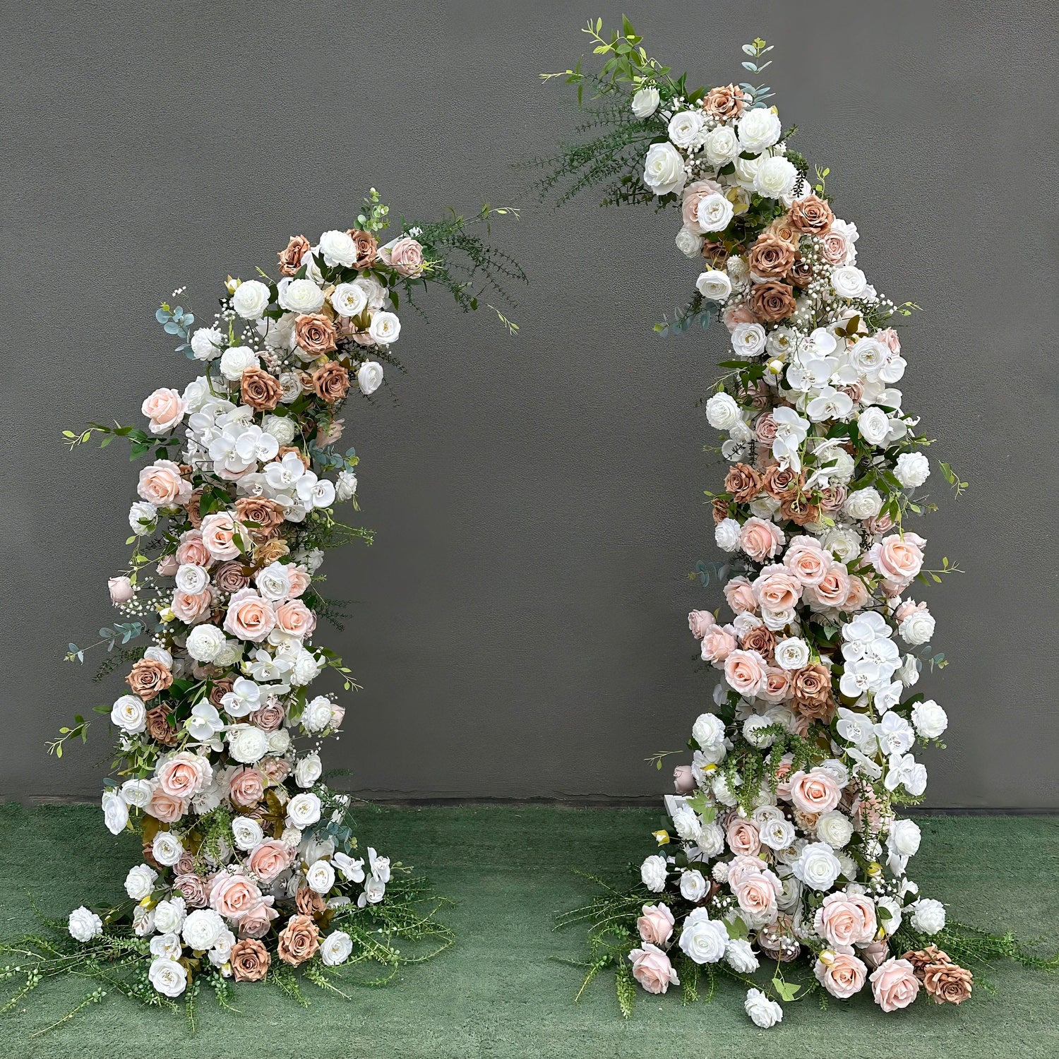 Beautifully designed artificial floral arch for weddings, ceremonies, and special events. Features blush pink, white, and earthy brown roses, plus white orchids with lush greenery. Arranged in a cascading effect on a sturdy frame. Ideal for indoor/outdoor use. Romantic, elegant, and timeless.