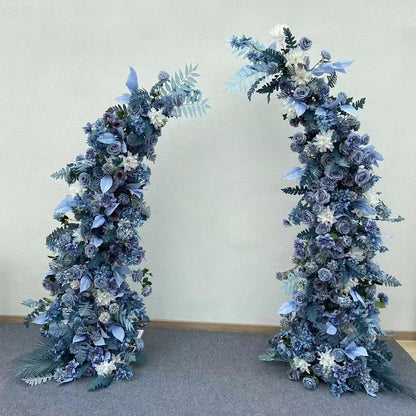 Exquisite artificial floral arch for weddings, ceremonies, and special events. Features blue and white flowers (roses, peonies, hydrangeas) with lush greenery, arranged in a cascading effect on a sturdy frame. Ideal for indoor/outdoor use. Sophisticated, romantic design.