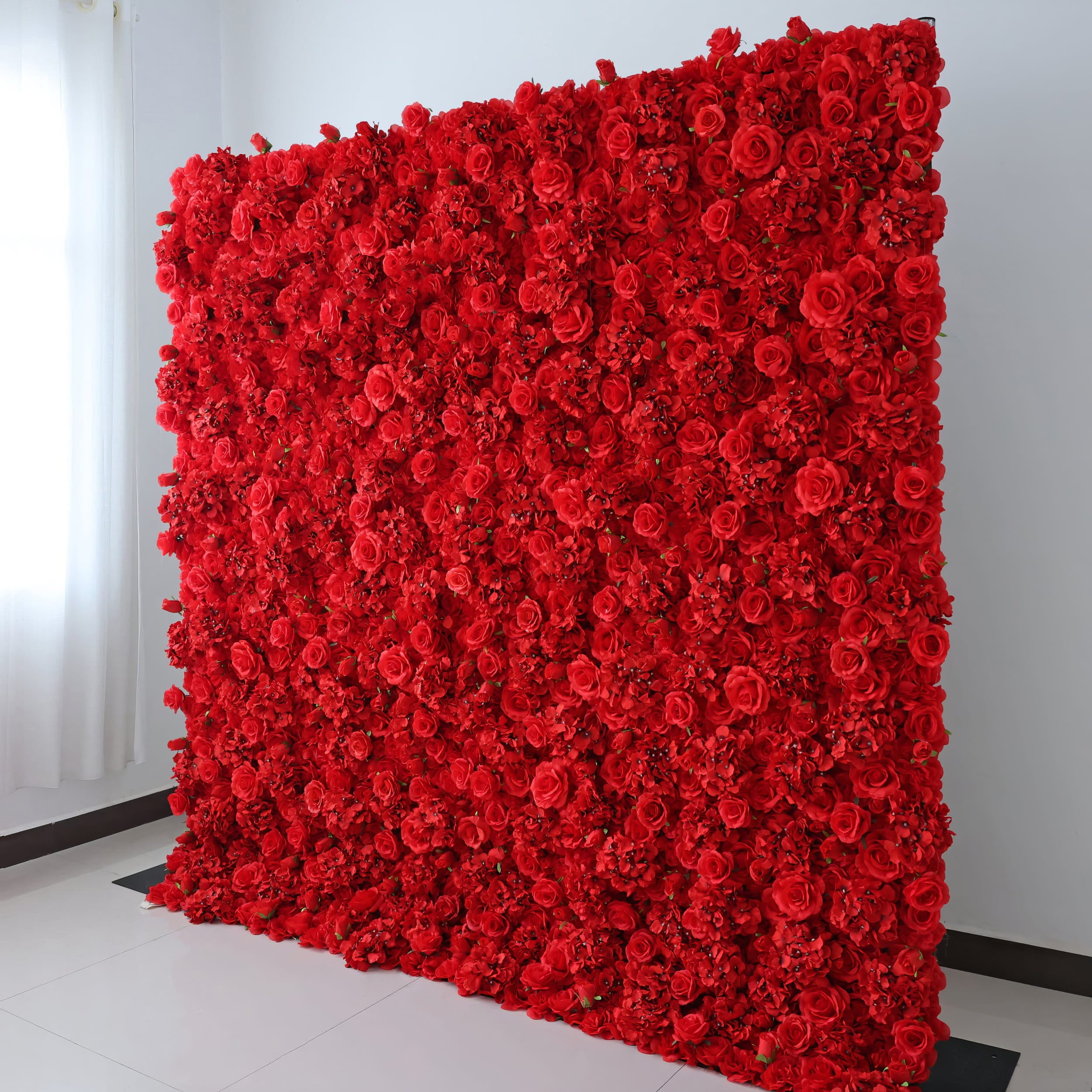 A stunning ValarFlowers red floral wall featuring a dense arrangement of roses and hydrangeas, set against a clean indoor backdrop. Perfect for luxurious events, adding elegance and romance to any space.