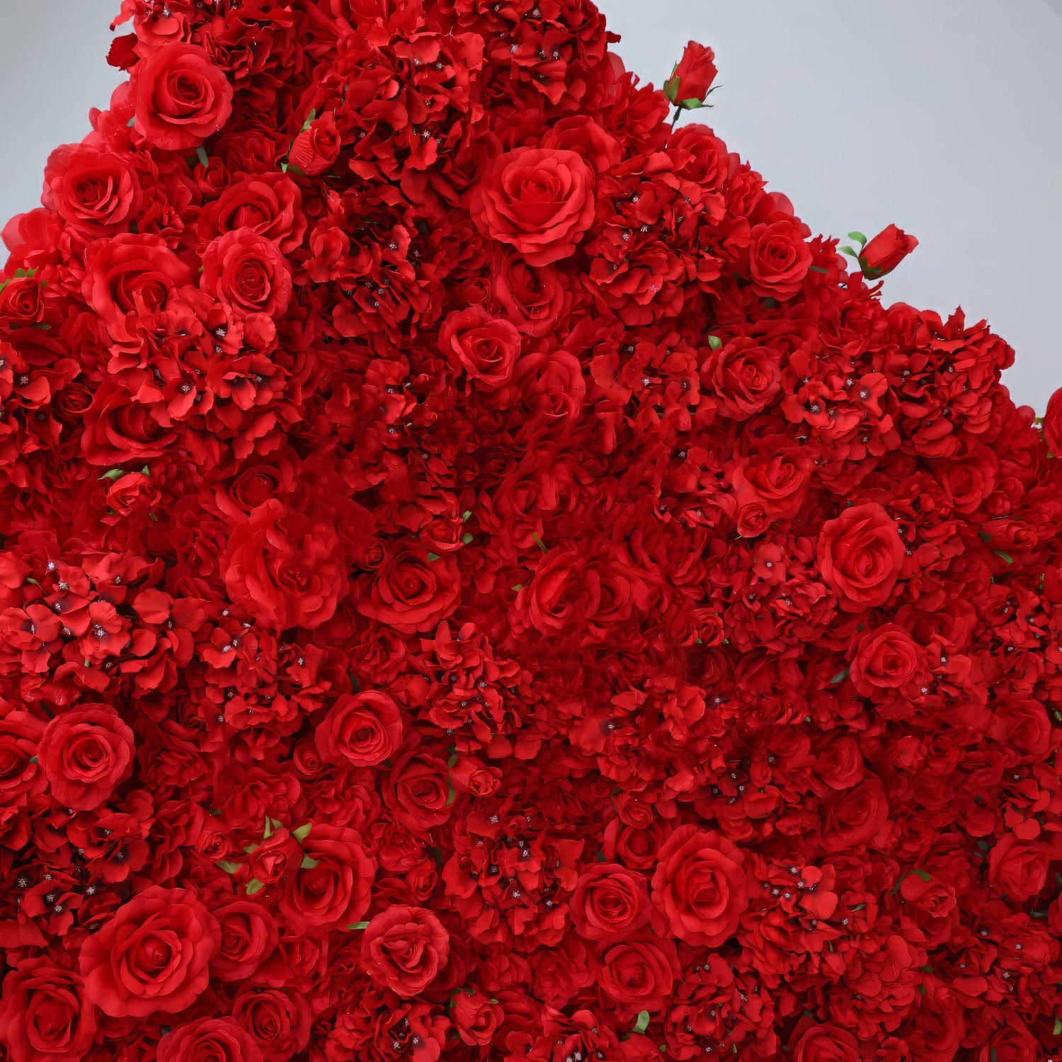 A close-up corner view of the ValarFlowers red flower wall, featuring an elegant mix of realistic silk roses and hydrangeas. Perfect for luxury events, it adds a vibrant, romantic ambiance.