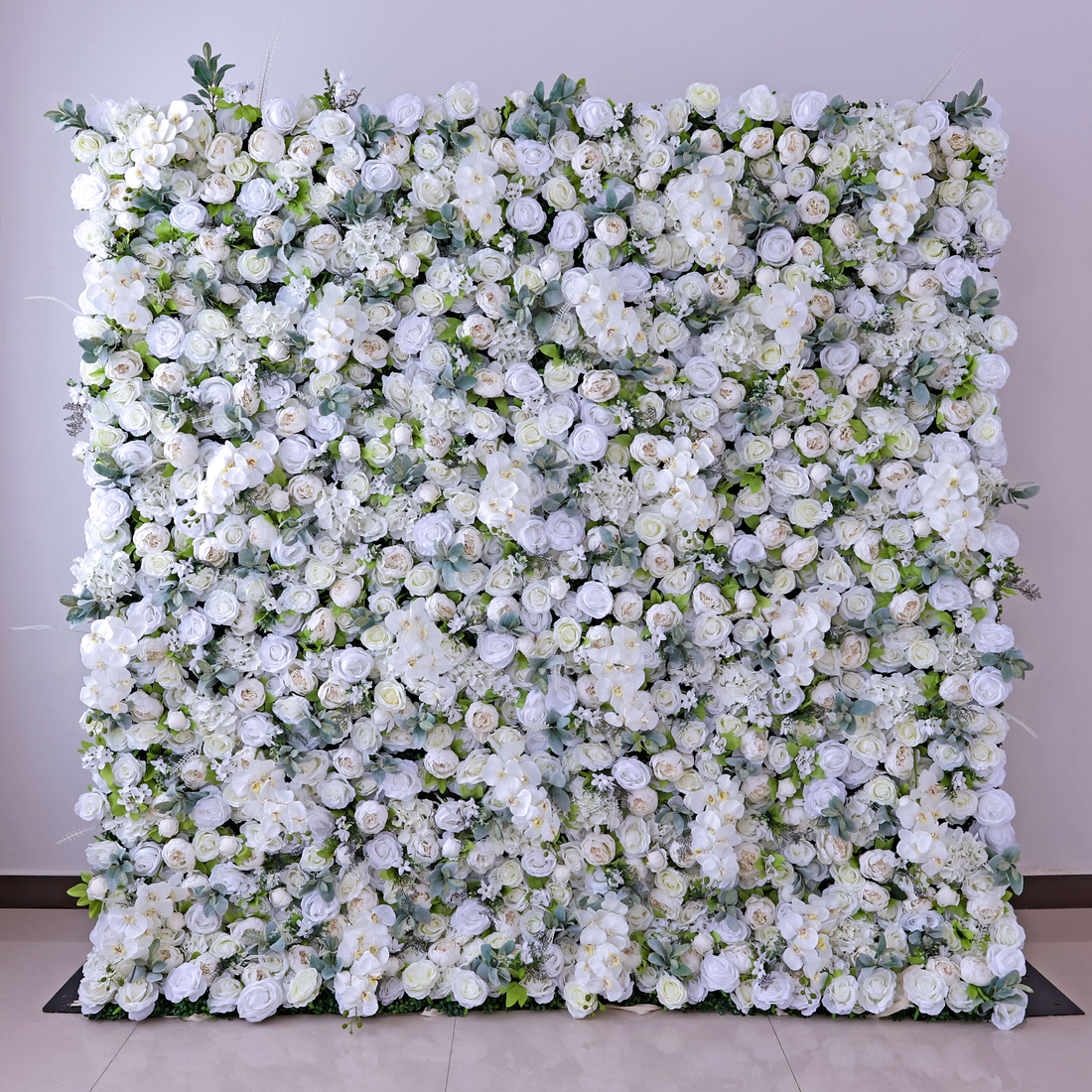 The arrangement features a variety of artificial flowers, predominantly white roses, along with other white blooms that resemble orchids and peonies. The leaves are primarily green, providing a lush and natural backdrop to the flowers.