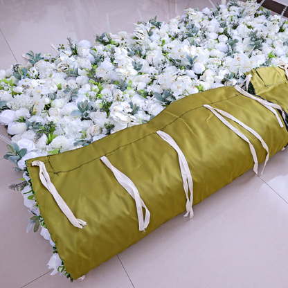 The image shows a ValarFlowers product: a rolled - up artificial flower wall with a green cover and white ties. It features a dense arrangement of white flowers, ideal for event decorations.