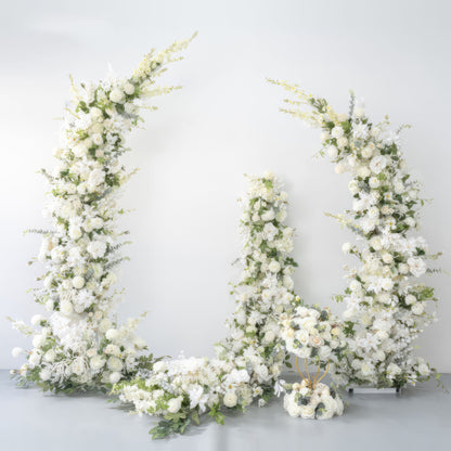 Elegant white floral arch with lush greenery, featuring roses and delicate blooms, creating a romantic and sophisticated setting. Ideal for weddings or special events, this arrangement offers a modern, luxurious backdrop.